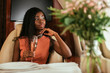© LIGHTFIELD STUDIOS - selective focus of dreamy african american woman holding glass of champagne in private jet
