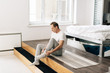 © LIGHTFIELD STUDIOS - handsome man wearing sock while sitting at home