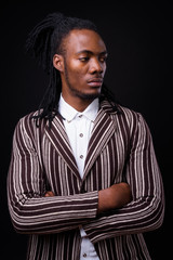 Wall Mural - Portrait of young handsome African businessman in suit with dreadlocks