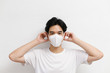 © Gengwit - Young asian male wearing medical face mask to protect corona virus, studio portrait.