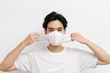 © Gengwit - Young asian male wearing medical face mask to protect corona virus, studio portrait.