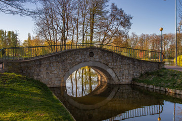 A bridge in the park near the water in the summer.