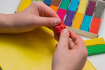 
child learns to sculpt from colored plasticine