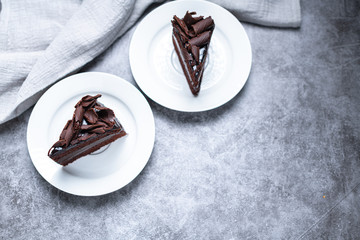 top view of 2 slices of sweet Chocolate cakes on the grey table, with copy space.