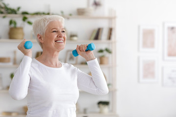 Wall Mural - Healthy Lifestyle. Smiling Senior Lady Exercising With Dumbbells At Home