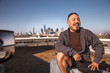 © SuperStock - Laughing man sitting on rooftop, Dallas, Texas, USA
