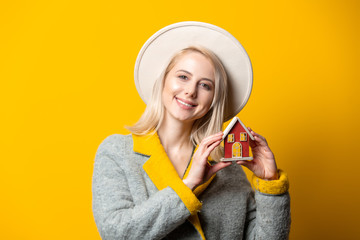 Sticker - Style blonde woman in hat and coat with toy house