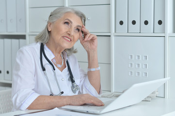 Wall Mural - Senior female doctor working at her cabinet