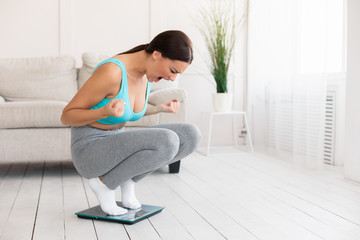 Angry Girl Shouting Standing On Weight-Scales At Home, Free Space