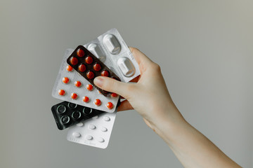 Girl holds pills in hands on a white background