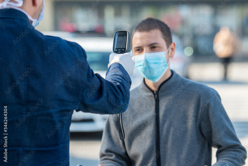 Temperature Check Commercial Temperature check at a supermarket of man, grocery store with thermal ...