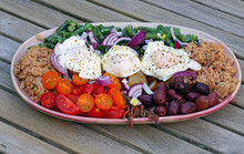 A Nicoise Salad With Poached Eggs, Canned Tuna, Anchovies, Tomatoes, Potatoes And Vegetable