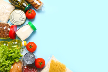 Wall Mural - Food supplies for the period of quarantine on blue background. Set of grocery items from canned food, vegetables, pasta, cereal. Food delivery concept. Donation concept. Top view.