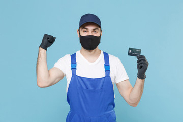 Wall Mural - Delivery man in cap t-shirt uniform sterile mask glove isolated on blue background studio Guy employee courier hold credit card Service quarantine pandemic coronavirus virus covid-19 2019-ncov concept