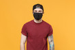 Young tattooed man guy in casual t-shirt cap black face mask posing isolated on yellow wall background studio portrait. People sincere emotions lifestyle concept. Mock up copy space. Looking camera.
