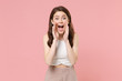 © ViDi Studio - Excited young brunette woman girl in light casual clothes posing isolated on pastel pink background in studio. People lifestyle concept. Mock up copy space. Screaming with hands gesture near mouth.