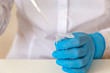 © September - A medical lab worker in blue sterile gloves pours liquid into a small test tube.