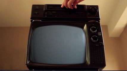 Wall Mural - male hand inserting a vhs into a vcr and an old tv green screen. you can replace green screen with t