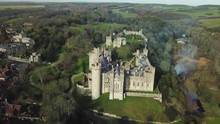 Aerial Drone View Of Old Castle On A Hill Surrounded By Forests On The Outskirts Of A Small Town. Arundel Castle - England