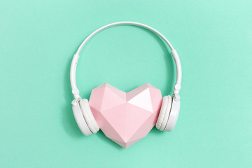 Poster - volumetric paper pink heart in white headphones. concept for music festivals, radio stations, music 