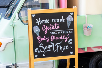 Gluten free, lactose free, gluten free ice cream sign. Advertisement on chalk board during food festival. Vintage retro italian car behind the sign. intolerance free dessert shop directional ad text