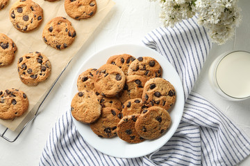 Wall Mural - Composition with chip cookies, flowers and milk on white table, top view