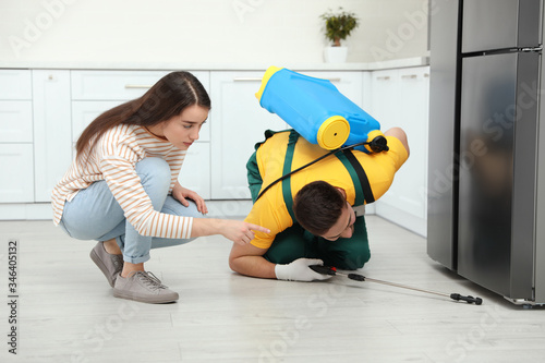 Woman showing insect traces to pest control worker in kitchen Poster Mural XXL