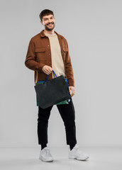 Wall Mural - sale and people concept - happy smiling young man with shopping bags over grey background