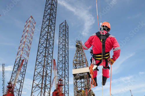 Fotomural Industrial rope access abseiler welder wearing safety harness, abseiling commenc