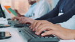 © art24pro - Close-up shot of operators hands typing on keyboard in modern office. People are busy working on the computer.