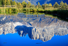Reflection Of Snowcapped Mountains And Lake Against Blue Sky