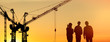 © New Africa - Silhouettes of engineers near construction site at sunrise. Banner design