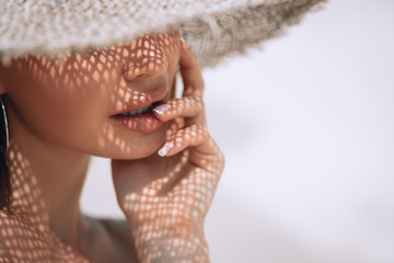 portrait of a beautiful woman in a straw hat with french manicure. cosmetics,makeup and beauty. spa.