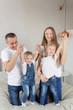 © Marharyta Manukha - Young family at home, kids jumping on the bed. Mom, Dad, two little daughters.