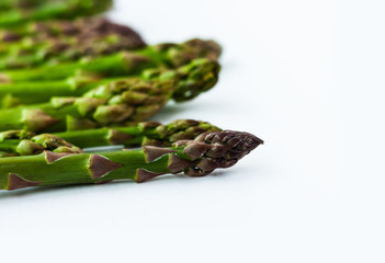 Bunch of fresh raw asparagus on white background, vegetarian concept. Green grass sparrowgrass sticks, food for veggie.