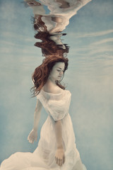 Wall Mural - Portrait of a girl in a white dress underwater