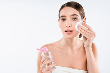 Wall Mural - Attractive half naked woman using facial lotion with cotton pad isolated over white background