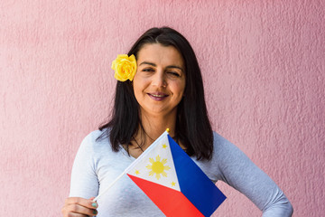 Sticker - Woman holds flag of Philippines in front of isolated wall background