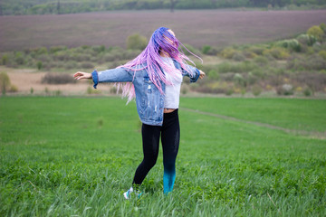 girl with dreadlocks on a green field