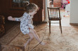 © Kiryakova Anna - A happy girl jumps through an elastic band strung between chairs. Idea for quarantined child activity