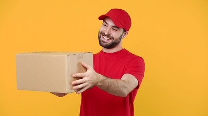 Wall Mural - Delivery young guy man in red cap blank t-shirt uniform workwear hold empty cardboard box isolated on yellow background studio Professional male deliveryman employee working as courier Service concept