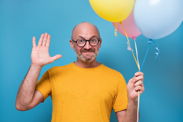 guy holding balloons, smiling, welcoming his friends.