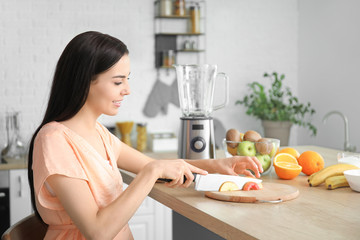 Sticker - Young woman making fruit smoothie in kitchen at home