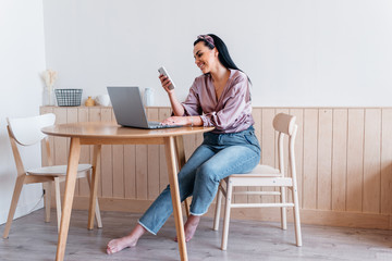 Wall Mural - Woman in the kitchen using laptop, working home, remote work