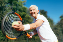 Smiling Elderly Woman Playing Tennis As A Recreational Activity