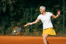 Smiling Elderly Woman Playing Tennis As A Recreational Activity