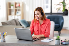 Remote Job, Technology And People Concept - Happy Smiling Young Woman With Headset And Laptop Computer Having Video Conference At Home Office