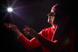 © keleny - Portrait of middle age woman in red sweater and the turban of wizard or sorcerer on black background. Actress in a magical, fantastic, fairy-tale movie. Female model posing at studio with low light
