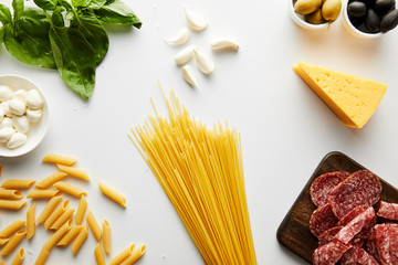 Wall Mural - Top view of spaghetti, meat platter, basil leaves and ingredients on white