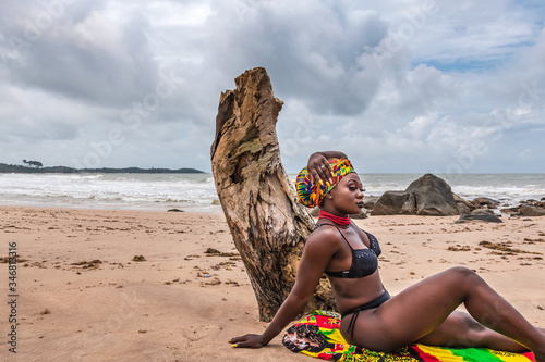 Plakat Ghana woman with a colorful blanket and headdress on a beach in Ghana West Africa